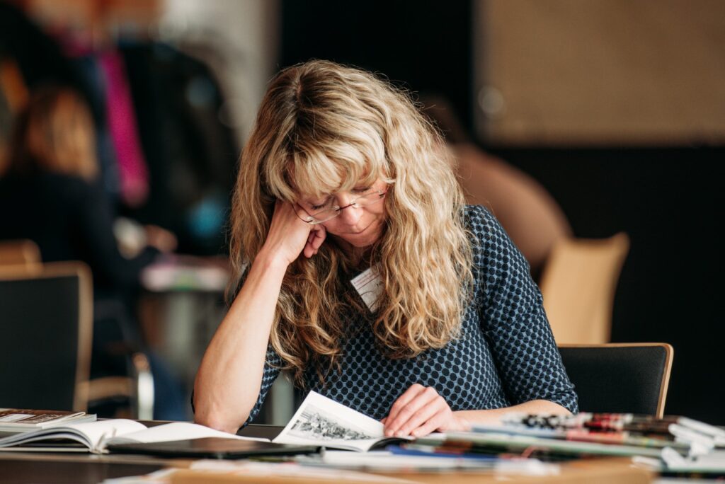 Eine Frau (Nikola John) liest eine Schülerzeitung während der Jurysitzung des Schülerzeitungswettbewerbes der Jugendpresse Deutschland