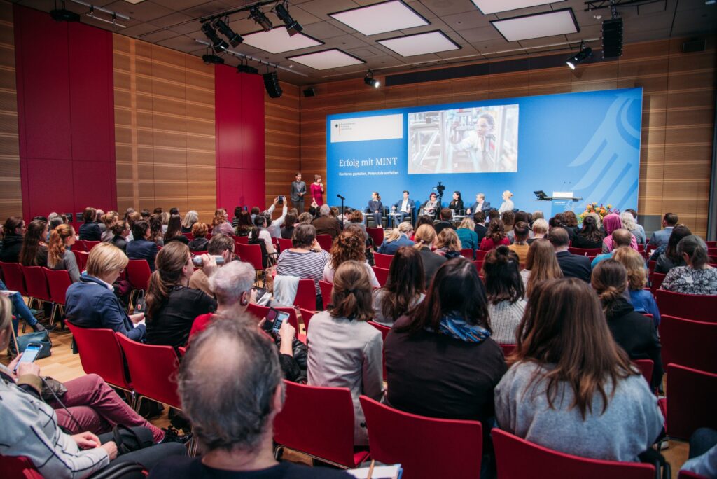 Menschen sitzen vor einer Bühne bei der Transfertagung "Erfolg mit MINT" des Bundesminsteriums für Bildung und Forschung 2020
