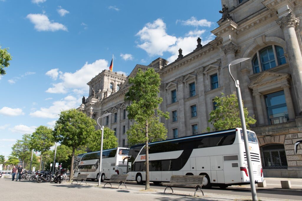 Der Reichstag in Berlin mit Reisebussen