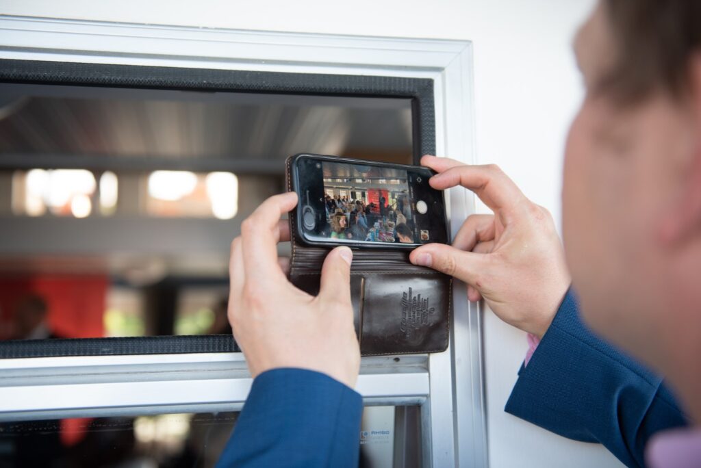 Eine Person fotografiert mit seinem iPhone die Rede von Olaf Scholz während der Spargelfahrt des Seeheimer Kreises 2022 auf dem Wannsee