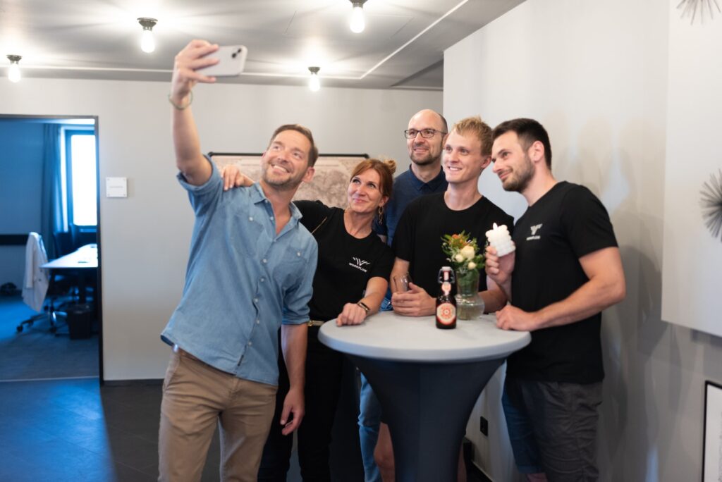 Eine Gruppe im MDR-Tower in Leipzig bei der Workflow Offices Büroeröffnung macht ein Gruppenselfie