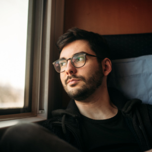 Fotograf Kurt Sauer sitzt in einem ICE der Deutschen Bahn und blickt aus dem Fenster