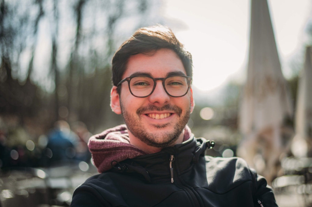 Kurt Sauer Portrait Fotograf Kurt Sauer lächelt in die Kamera, trägt eine Softshelljacke und einen roten Pulli