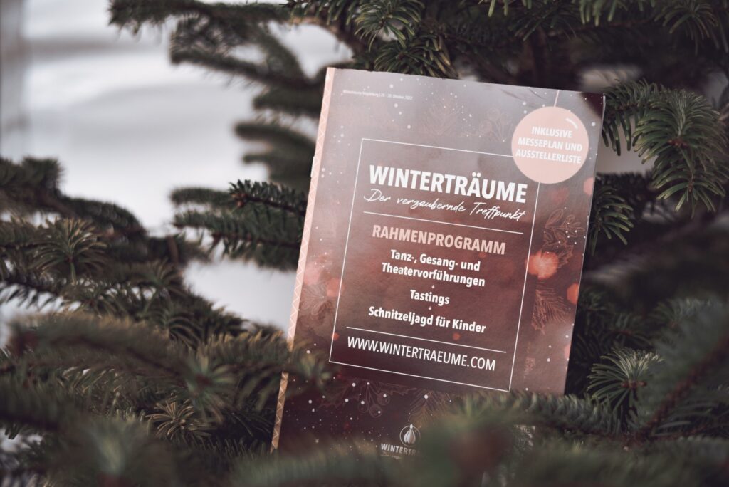 Das Programmhelft der Winterträume-Messe 2022 in Magdeburg liegt in einem Baum